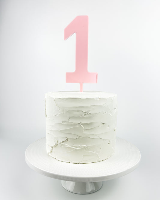 White cake with a pink number candle on a white background