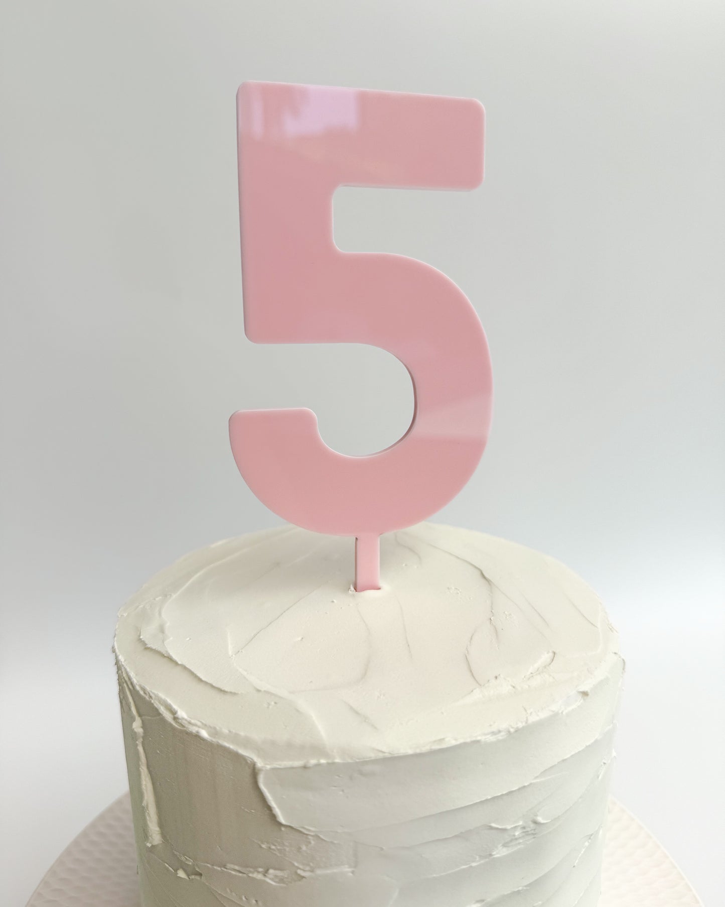 Blush pink number cake topper on white cake